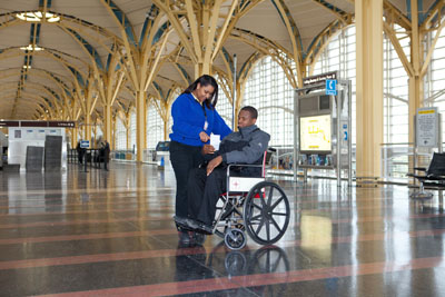 staff assisting person in a wheelchair