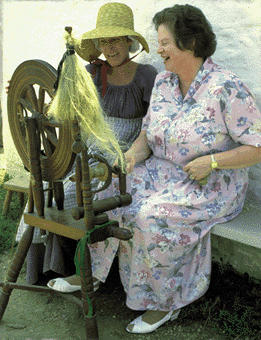Woman who is blind is learning how to spin flax at the Museum of Frontier Culture